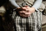 Hands folded together on lap