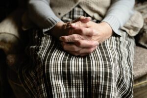 Hands folded together on lap